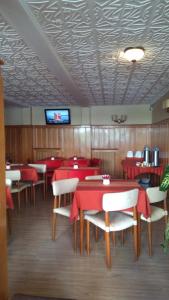 圣卡洛斯-德巴里洛切皮尤科酒店的餐厅设有红色的桌椅和电视。