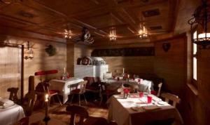 摩德纳迪-坎皮格里奥多尔齐维塔小木屋精品酒店的一间在房间内配有桌椅的餐厅