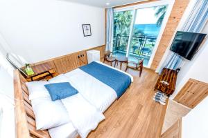 西归浦市济州奥鲁姆度假屋的一间卧室设有一张床和一个大窗户