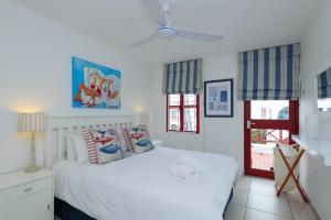 巴利托Le Paradis 25的卧室配有白色的床和2扇窗户。
