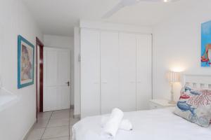 巴利托Le Paradis 25的卧室配有白色的床和白色衣柜。