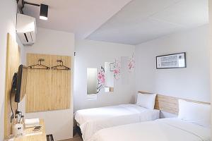 罗勇Izen Plus Budget Hotel & Residence的一间酒店客房,设有两张床和电视