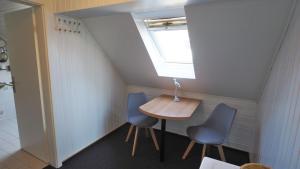 比苏姆Westerstrasse Kajüten的小房间设有桌子和两把蓝色椅子