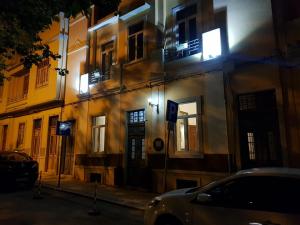 法鲁Guest House do Largo的一座晚上停着汽车的建筑