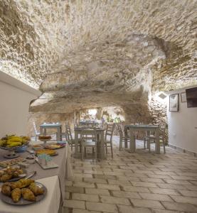 夏卡Casa dell'Aromatario b&b的一间设有桌子和石墙的用餐室