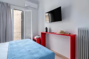 雅典Koukaki Central Apartment的卧室配有一张床,墙上配有电视。