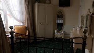 韦茅斯海湾旅馆的一间卧室配有一张带镜子和桌子的床