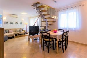 科尔丘拉Apartments Viva的用餐室以及带桌子和螺旋楼梯的客厅。