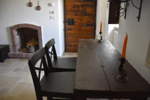 阿尔贝罗贝洛Masseria Mazzalorsa的一间带木桌和壁炉的用餐室