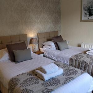 鲍内斯温德米尔墨尔本宾馆的客房内的两张床和毛巾