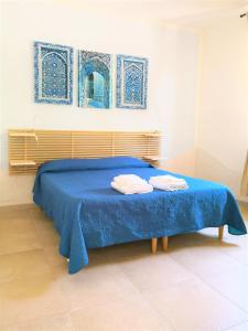 塔兰托迪莫拉马里尤住宿加早餐旅馆的蓝色的床,上面有两条毛巾