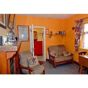 法伦福尔Hannah's Cottage的客厅配有两把椅子和红色冰箱