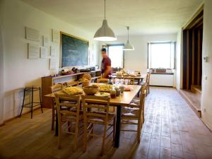 贝瓦尼亚Ostello Bello Assisi Bevagna的厨房以及带桌椅的用餐室。