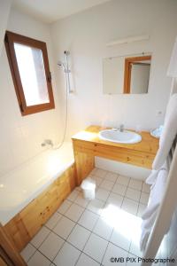 Anthy奥格昂西酒店的一间带水槽、浴缸和镜子的浴室