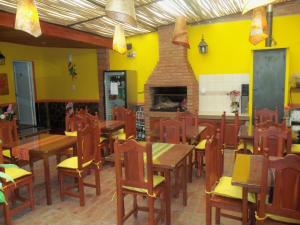 萨尔塔米亚妈妈宾馆的餐厅拥有黄色的墙壁和木桌及椅子