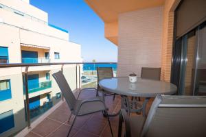 阿瓜杜尔塞apartamento aguadulce playa con WIFI的阳台配有桌椅。