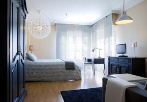 马德里TH阿拉瓦卡酒店的客厅配有一张床和一张书桌及电视