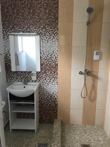 科斯蒂内什蒂Babylonia Resort的一间带水槽、镜子和淋浴的浴室