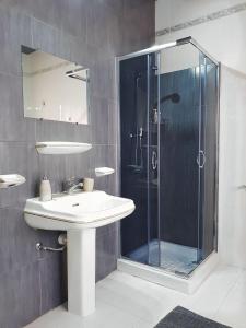 圣保罗湾城Villa Zammitella的一间带水槽和玻璃淋浴的浴室