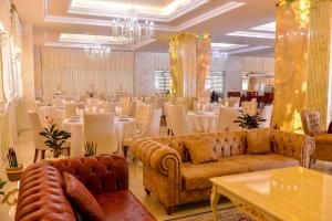 巴库Ammar Grand Hotel的一间带桌子和沙发的房间以及一间带桌椅的房间