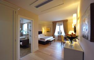 埃尔萨谷口村帕拉佐圣洛伦索Spa酒店的酒店客房设有床和客厅。