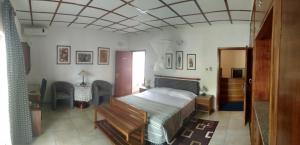 拉各斯曼努埃拉住宿酒店的卧室配有一张床和一张桌子及椅子