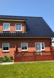 博尔滕哈根Redewischer Str.23e的黑色屋顶红砖房子