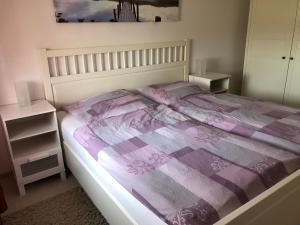 博尔滕哈根Redewischer Str.23e的一间卧室配有一张带紫色棉被的床