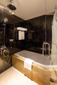多哈Ezdan Palace Hotel的设有带浴缸和淋浴的浴室。