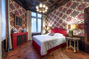 鲁昂La Maison Des Vieux Logis的卧室配有一张床铺,位于带花卉壁纸的房间
