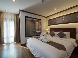 清迈兰纳树精品酒店的一间卧室设有一张大床和大窗户