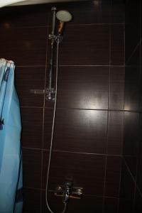 哈尔科夫Современная 1-комнатная квартира的浴室设有棕色瓷砖墙和淋浴。