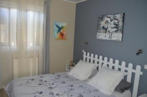莫桑克斯a2pasdelaforet的一间卧室配有一张带白色床单的床和一扇窗户。