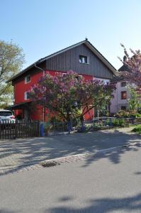 卡尔斯鲁厄Punkrock Harbour Pension Bähr的红色的建筑,有一棵树,花粉红色