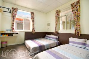 马公澎湖香亭民宿的带2扇窗户的客房内的2张床