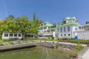 沃尔特湖畔佩莎赫Strandhotel Kärntnerhof的从水面上可欣赏到酒店的景色