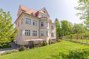 捷克克鲁姆洛夫贝阿提卡别墅精品酒店的前面有草坪的大房子