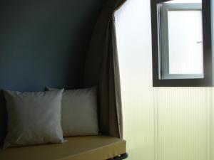 旺多姆旺多姆中心露营地的一间卧室配有一张带窗户和枕头的床