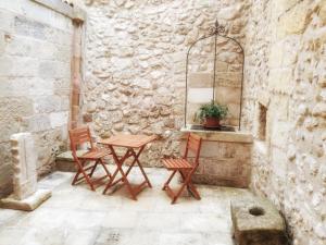 马尔塔诺Dimora Krifò的庭院设有两把椅子和一张石墙桌子。