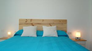 厄尔梅达诺The Beach House的一间卧室配有蓝色的床和2个白色枕头