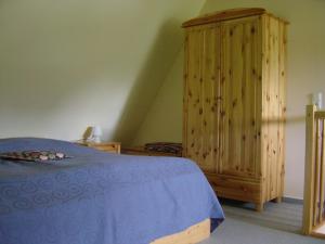 青斯特Ferienwohnung am Strand的一间卧室配有一张床和一个木制橱柜
