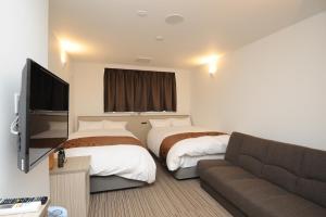 四万十市四万十市阳光河流酒店的酒店客房,设有两张床和一张沙发