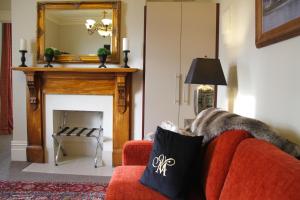 基督城梅尔瓦拉庄园酒店的客厅设有红色的沙发和壁炉