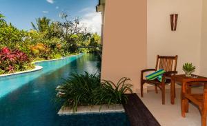 安汶纳特斯帕度假村及会议中心的房屋设有桌椅,享有游泳池的景致。