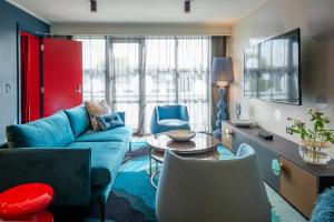 奥克兰奥克兰机场那欧米酒店的客厅配有蓝色的沙发和桌子