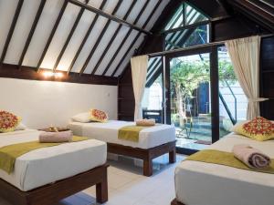 吉利特拉旺安吉利海龟度假酒店的客房设有三张床和大窗户