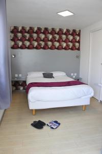 普卢巴拉内克贝德潘波勒酒店的卧室配有一张大床,地板上备有内衣