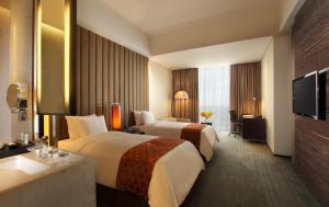 三宝垄PO Hotel Semarang的酒店客房设有两张床和电视。