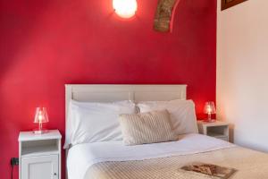 维罗纳维罗奈塔住宿加早餐旅馆的红色卧室配有一张带两盏灯的白色床