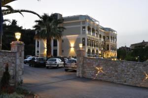 科孚镇Corfu Mare Hotel -Adults only的停车场内停放汽车的大型建筑